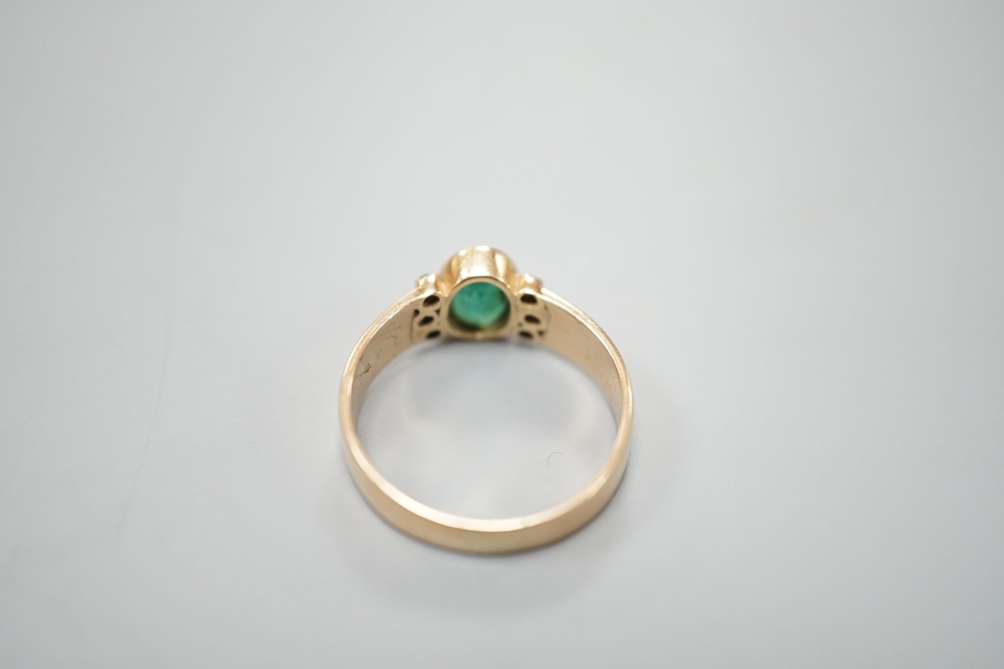 A yellow metal, oval cut emerald and six stone diamond chip set ring, size O, gross weight 3 grams.